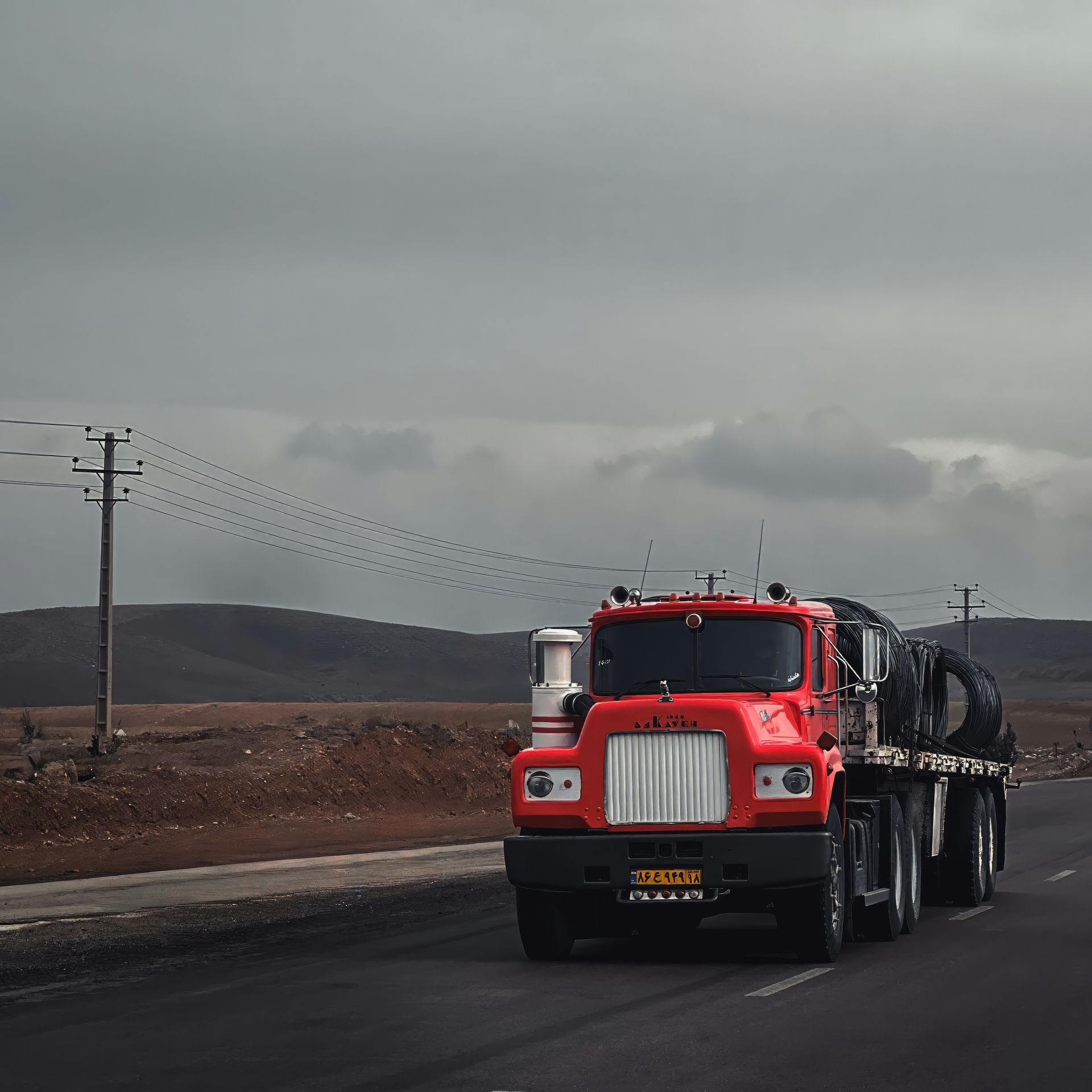 a red semi truck driving down a road